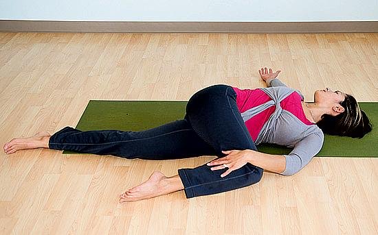 Young Lady In Supine Spinal Twist Pose